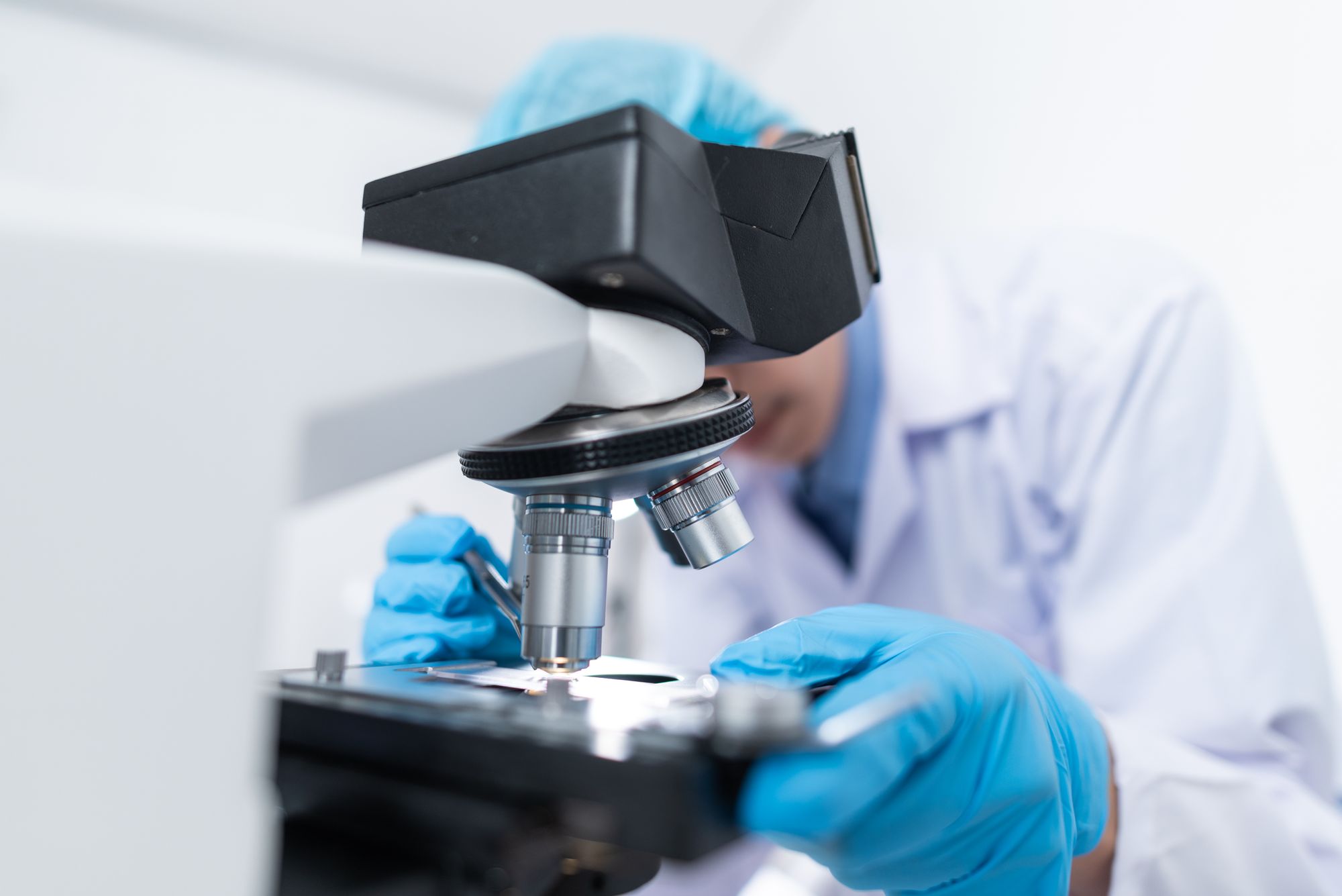 Lab technician examining a sample under the microscope